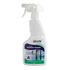 A white plastic spray bottle with handgrip  and white plastic spray mechanism. Bottle is labelled Abode natural Window Cleaner 500ml streak free, no bleach or ammonia, non citrus (D-limonene free), microfibre cloth compatible.
